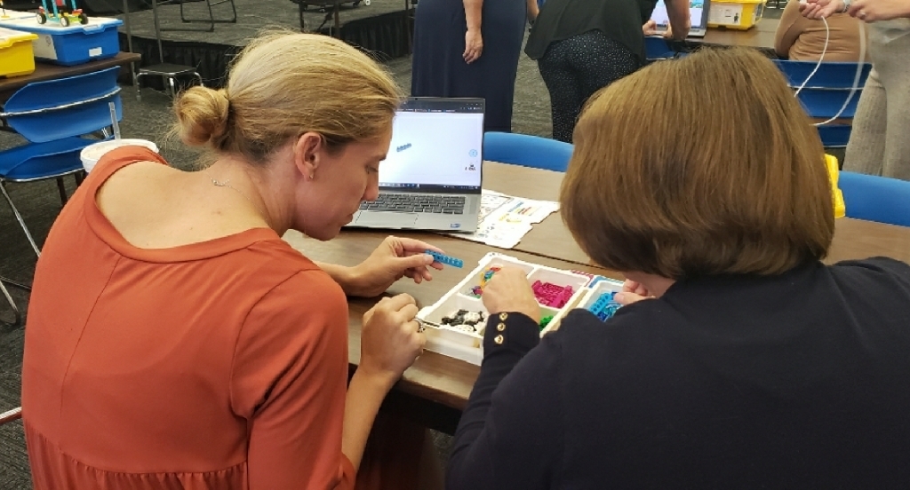 Katie and Jo Ann building a Lego robot.