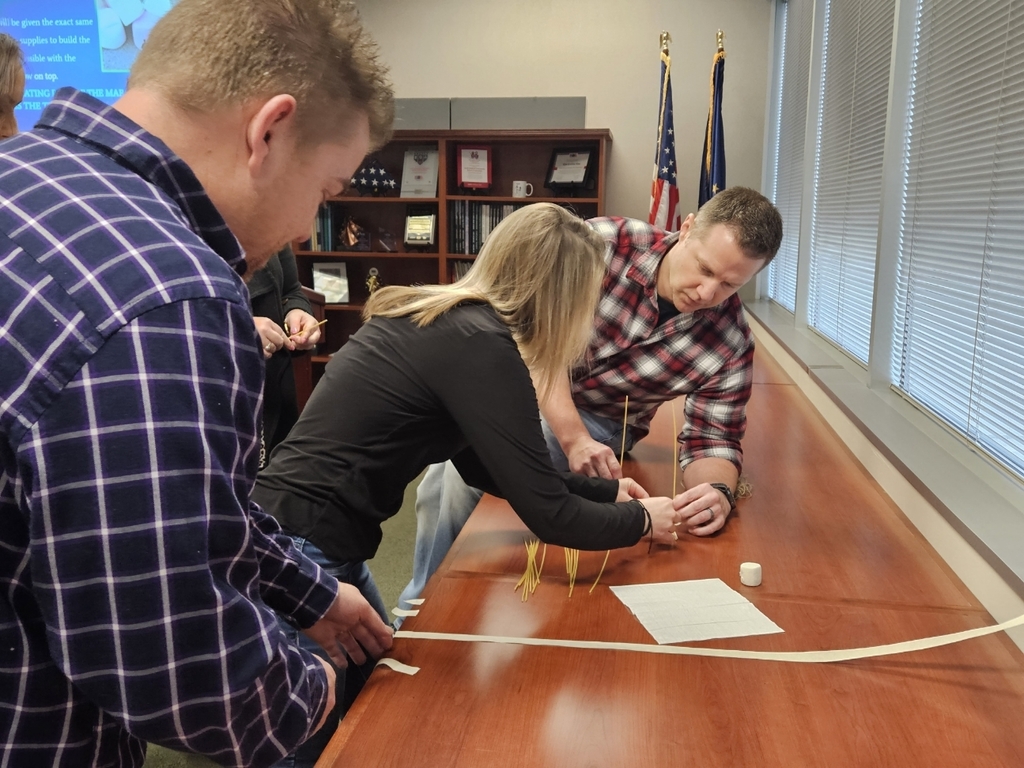 Teachers work together to build a structure. 