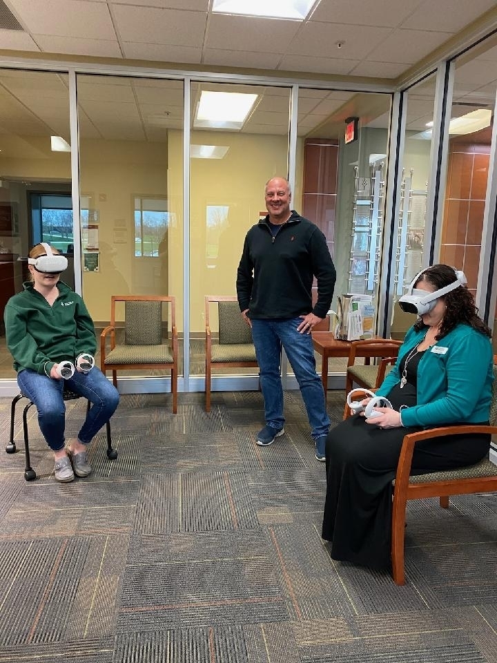 Ivy Tech employees experience the VR headsets as Jim Bisesi watches. 