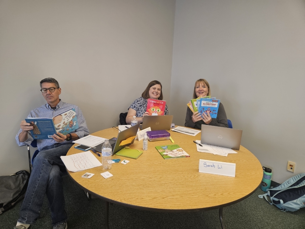 Educators show off their new books while Paul reads. 